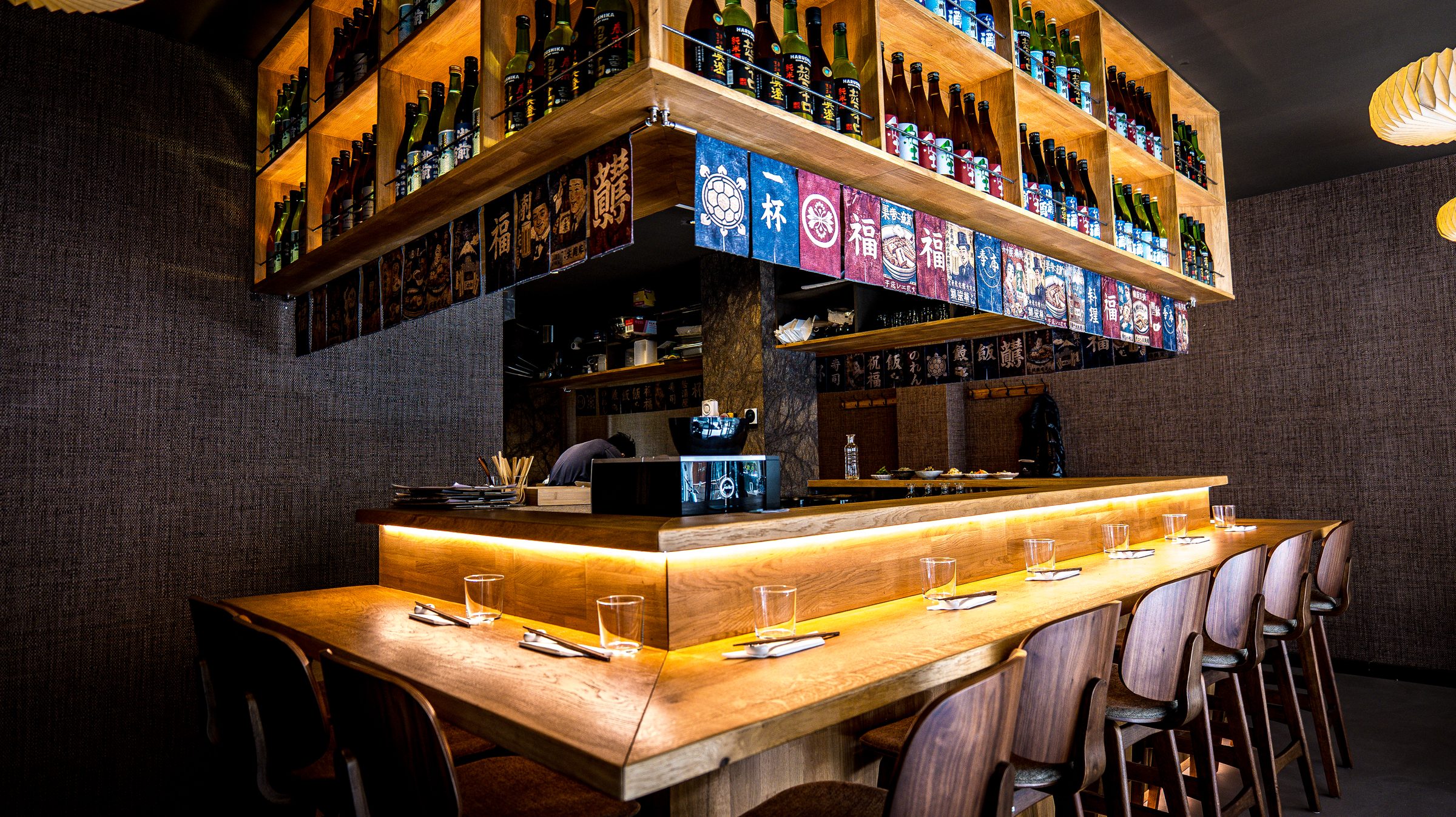 Le comptoir en bois de Yukihira, cuisine ouverte et mur de sakés
